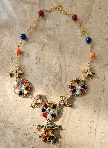 A colorful beaded necklace with a gold-tone chain and various geometric patterned pendants.