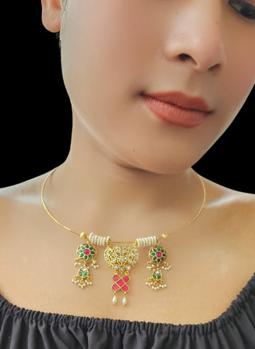 A person wearing a Gold Hasli pendant necklace with kundan and meena elements accented with pearl rings.