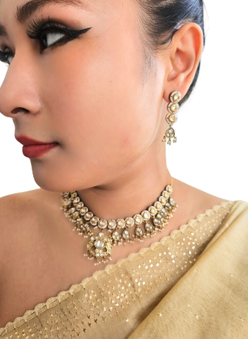 Close-up of a woman wearing gold jewelry including earrings and a necklace
