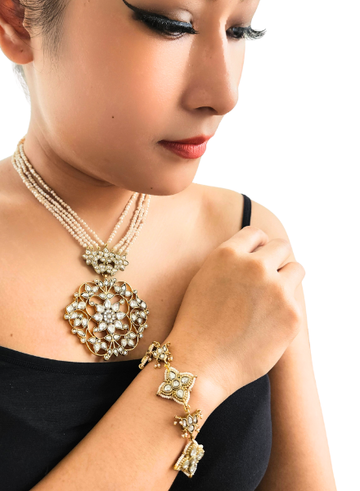 Woman wearing a gold necklace and bracelet 
