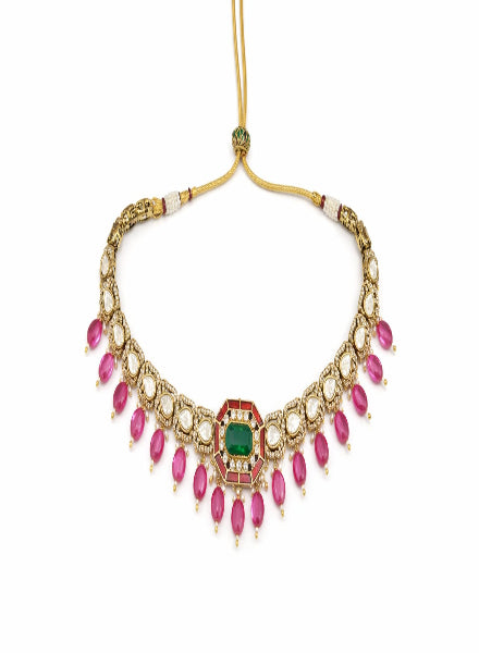 Gold necklace with pink gemstones and a green center stone 